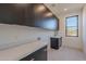 Bright laundry room with quartz countertops and dark cabinets at 25580 N 119Th St, Scottsdale, AZ 85255