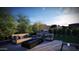 Seating area features a modern couch, chairs, and black rock fire pit on the patio at 25580 N 119Th St, Scottsdale, AZ 85255