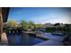 An exterior shot showing the pool with seating areas, greenery, and desert landscaping at 25580 N 119Th St, Scottsdale, AZ 85255