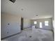 Large open-concept living room with neutral paint and concrete floors with walk out door at 26293 W Desert Crest St, Casa Grande, AZ 85193