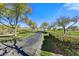 Landscaped community entrance with paved road and mature trees at 3190 S Jacaranda Ct, Gold Canyon, AZ 85118