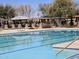 A community swimming pool, featuring multiple lanes, a pergola covered lounge area, and immaculately maintained grounds at 4072 S Skyline Ct, Gilbert, AZ 85297