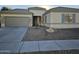 Beige house with gray garage door, stone accents, and landscaping at 4072 S Skyline Ct, Gilbert, AZ 85297