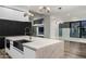 Modern kitchen with large island, black cabinets, and marble countertops at 4129 E Sandy Mountain Rd, Paradise Valley, AZ 85253
