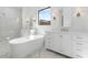 Bright bathroom featuring dual vanities, soaking tub, large windows, and neutral finishes at 42103 N Cutbow Trl, San Tan Valley, AZ 85140