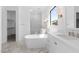 Bright bathroom featuring dual vanities, soaking tub, large windows, and neutral finishes at 42103 N Cutbow Trl, San Tan Valley, AZ 85140