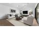 Bright living room with white furniture, modern art, wood floors, and high ceilings at 42103 N Cutbow Trl, San Tan Valley, AZ 85140