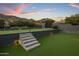 Putting green with lighted stairs, turf, and mountain views at 7223 N Black Rock Trl, Paradise Valley, AZ 85253