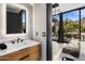 Contemporary bathroom with marble vanity and view of backyard at 7223 N Black Rock Trl, Paradise Valley, AZ 85253