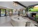 Open living area with curved sofa, fireplace, and kitchen views at 7223 N Black Rock Trl, Paradise Valley, AZ 85253