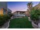 Lush backyard with artificial turf, a cozy patio area, string lights, and beautiful landscaping, ideal for relaxation at 7929 N 55Th St, Paradise Valley, AZ 85253