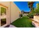 Private backyard with artificial turf, outdoor kitchen, and desert landscaping at 7929 N 55Th St, Paradise Valley, AZ 85253