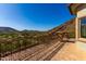 Spacious balcony with stone accents and wrought iron details provides breathtaking views of the desert terrain at 7929 N 55Th St, Paradise Valley, AZ 85253