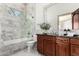 Elegant bathroom with marble tile, a glass-enclosed shower/tub, and a rich wooden vanity at 7929 N 55Th St, Paradise Valley, AZ 85253