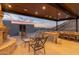 Covered outdoor patio with a built-in grill, fireplace, and comfortable seating, offering a perfect spot for outdoor dining at 7929 N 55Th St, Paradise Valley, AZ 85253