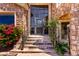 Elegant entryway featuring a custom front door, stone accents, steps with wrought iron railings, and lush greenery at 7929 N 55Th St, Paradise Valley, AZ 85253