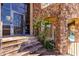Elegant stone entryway with a custom iron door, stone steps, wrought iron railings, and lush greenery at 7929 N 55Th St, Paradise Valley, AZ 85253