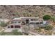 A sprawling multi-story home featuring a private pool and a stone exterior nestled in a mountainside landscape at 7929 N 55Th St, Paradise Valley, AZ 85253
