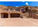Elegant stone home with a large garage, landscaped entry, wrought iron details, and a grand façade at 7929 N 55Th St, Paradise Valley, AZ 85253