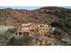Beautiful hillside house boasts a stone facade, multi-level terraces, a pool, lush landscaping and mountain views at 7929 N 55Th St, Paradise Valley, AZ 85253