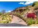 Stunning stone mansion perched on a hillside with a private drive, lush landscaping, and scenic views at 7929 N 55Th St, Paradise Valley, AZ 85253