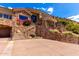 Beautiful stone home with an ornate wrought iron staircase, landscaped terraces, and elegant architectural details at 7929 N 55Th St, Paradise Valley, AZ 85253
