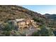 Elegant stone house with a red tile roof, built on a rocky hillside, showcasing unique architecture and outdoor living spaces at 7929 N 55Th St, Paradise Valley, AZ 85253