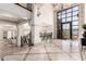 Grand foyer with high ceilings, travertine floors, custom iron staircase, and an ornate chandelier at 7929 N 55Th St, Paradise Valley, AZ 85253