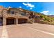 Elegant stone home with a spacious three-car garage, arched entryways, and an expansive driveway at 7929 N 55Th St, Paradise Valley, AZ 85253