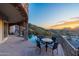 Balcony with wrought iron railing includes chairs and a table set for 4 people with sunset views of city and mountains at 7929 N 55Th St, Paradise Valley, AZ 85253