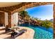 Luxury pool and waterfall feature with lush landscaping and inviting lounge chairs for relaxing outdoors at 7929 N 55Th St, Paradise Valley, AZ 85253