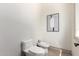 Simple powder room with white fixtures, light walls, and elegant artwork at 7929 N 55Th St, Paradise Valley, AZ 85253