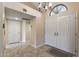 Bright entryway with double doors, tile flooring and chandelier at 13051 W Blue Sky Dr, Sun City West, AZ 85375