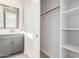 Modern bathroom with gray vanity, spacious closet, and a large mirror at 17449 W El Caminito Dr, Waddell, AZ 85355