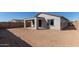 Covered patio and spacious backyard with desert landscaping at 17455 W El Caminito Dr, Waddell, AZ 85355