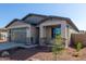 New construction home with gray garage door and stone accents at 17455 W El Caminito Dr, Waddell, AZ 85355