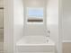 Bathroom featuring a soaking tub and a window for natural light at 17636 W Pierson St, Goodyear, AZ 85395