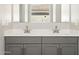 Bathroom featuring double sinks, quartz countertops, gray cabinetry and a large mirror at 17636 W Pierson St, Goodyear, AZ 85395