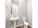 This half bath features a pedestal sink, a modern mirror and fixtures at 17636 W Pierson St, Goodyear, AZ 85395