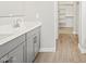 Bathroom with double sinks, gray cabinetry, tile floor, and a view of the walk-in closet at 17636 W Pierson St, Goodyear, AZ 85395