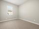 Bedroom offers neutral carpeting, natural light from the window, and neutral walls at 17636 W Pierson St, Goodyear, AZ 85395