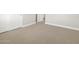 A well-lit bedroom showcasing neutral carpeting, clean white baseboards, and a nearby door to the adjacent room at 17636 W Pierson St, Goodyear, AZ 85395