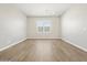 A spacious, bright room with wood-look tile flooring and a large window at 17636 W Pierson St, Goodyear, AZ 85395