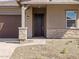 Close-up of the home's entrance featuring a dark wood door and stone veneer accents at 17636 W Pierson St, Goodyear, AZ 85395