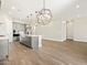 Open-concept kitchen with grey cabinets, island, stainless steel appliances, and modern sphere chandeliers at 17636 W Pierson St, Goodyear, AZ 85395