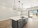 Stylish kitchen island with quartz countertop, stainless steel appliances, and pendant lighting at 17636 W Pierson St, Goodyear, AZ 85395
