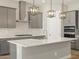 Stylish kitchen featuring gray cabinets, white countertops, and modern pendant lighting at 17636 W Pierson St, Goodyear, AZ 85395