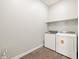 This is a laundry room with a washer and dryer, wooden flooring, and built in shelving for extra storage space at 17636 W Pierson St, Goodyear, AZ 85395