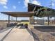 This outdoor kitchen features a built-in grill, counter space, dining table, and shade in a community outdoor common area at 17636 W Pierson St, Goodyear, AZ 85395