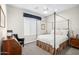 Bright bedroom featuring a four-poster bed and window seating at 18391 N 97Th Pl, Scottsdale, AZ 85255